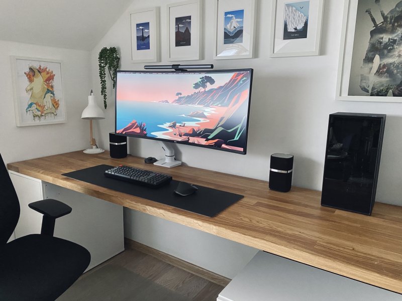 Oficina en casa de un teletrabajador con un brazo de monitor que sujeta la pantalla sobre el escritorio