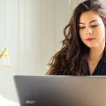 Una mujer escribe en el ordenador portátil una carta de recomendación para un excompañero de trabajo