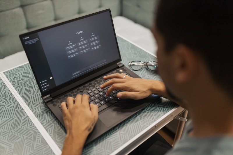 Un hombre utiliza la inteligencia artificial ChatGPT con el ordenador portátil para trabajar desde su casa