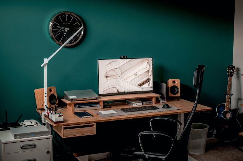 Oficina en casa con la pared pintada de color verde para aportar concentración a la persona que hace teletrabajo