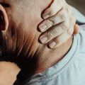 Un hombre sufre dolor de cuello a causa de la posición que tiene delante el ordenador