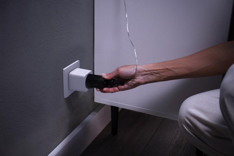 Conexión de un enchufe inteligente con una toma de corriente de la pared de un hogar