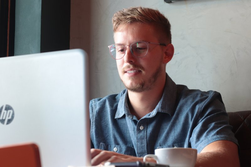 Un hombre consulta una web de empleo con el ordenador portátil para encontrar trabajo rápido