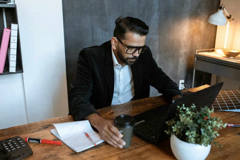 Un teletrabajador está en su home office e intenta corregir errores cometidos con el ordenador portátil