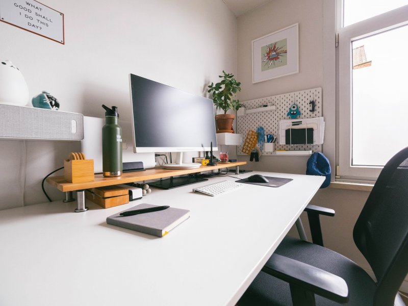 Escritorio rectangular en una oficina en casa, con un monitor, un teclado y un mouse para que los use la persona para teletrabajar