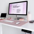 Escritorio regulable en altura eléctrico con un ordenador en la oficina en casa de un trabajador
