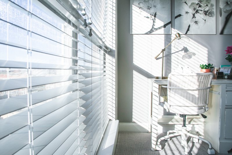 Oficina en casa con las persianas bajadas y las ventanas cerradas para mantener el frescor en casa en el verano