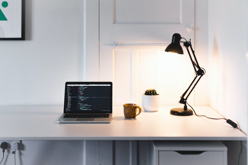 Una lámpara de mesa ilumina el escritorio de una oficina en casa