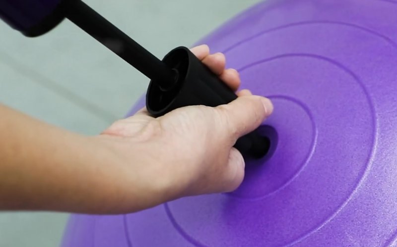 Una persona hincha una pelota de Pilates