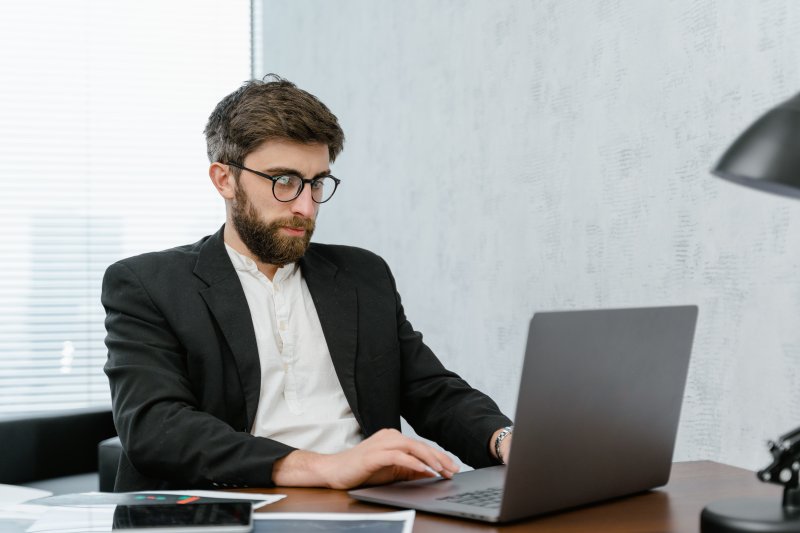 Un hombre entra a internet con el ordenador portátil para realizar una investigación de la empresa con la que tiene que hacer una entrevista de trabajo