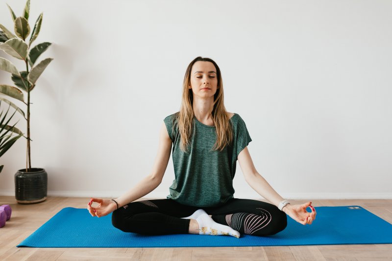 Una mujer hace mindfulness durante una jornada laboral de teletrabajo en su casa