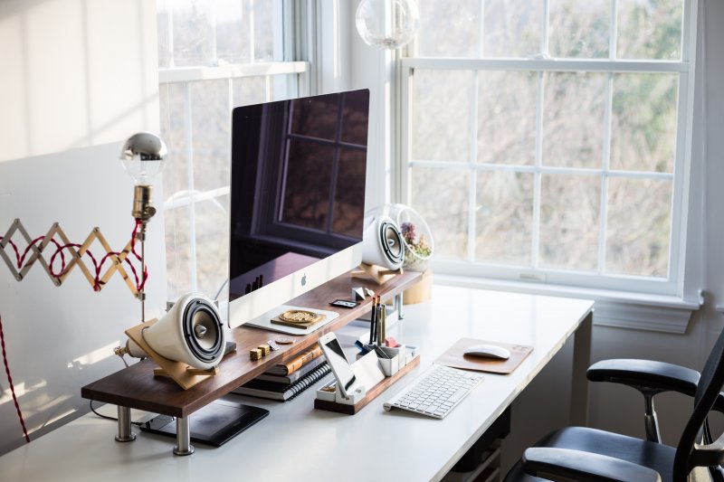 Home office con escritorio, silla de oficina ergonómica, ordenador y teléfono móvil