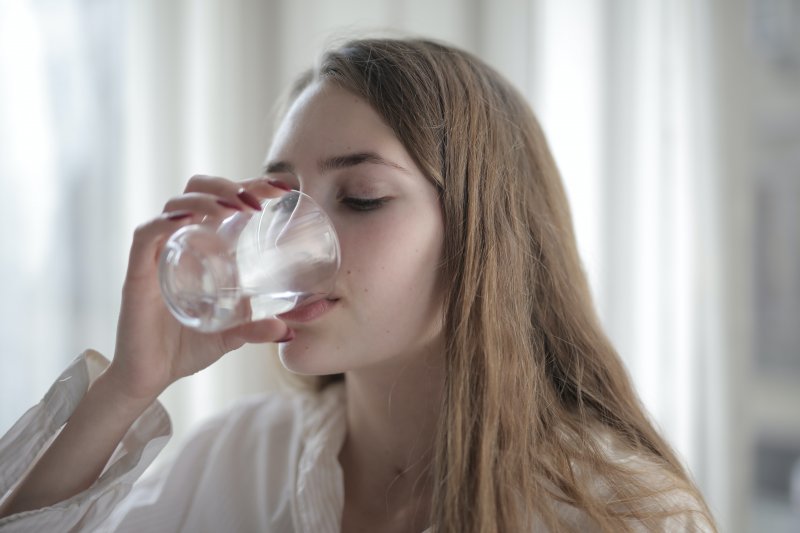 Una mujer bebe un caso de agua en su casa para no deshidratarse