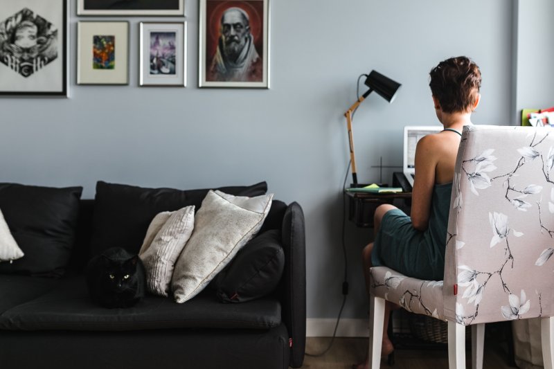 Una mujer trabaja con su laptop en la oficina que tiene instalada en casa y que es de dimensiones pequeñas