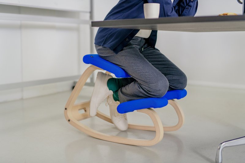 Una silla de rodillas con mecedora que utiliza un hombre para trabajar desde su casa