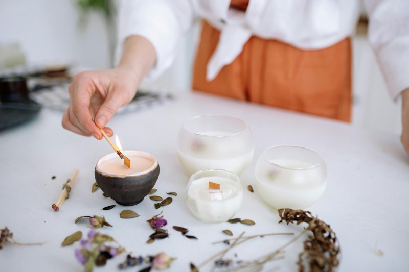 Una mujer enciende velas aromáticas para ambientar su casa